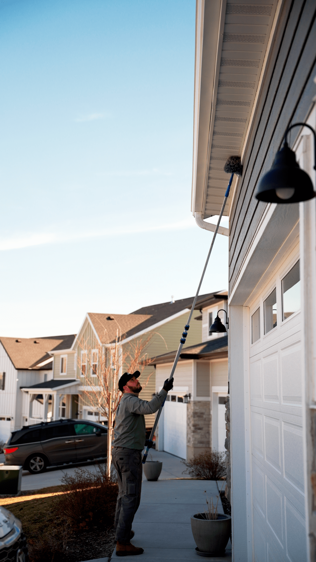 Natures Balance Pest Control Service Specialist dewebbing a utah homes eaves for spider webs